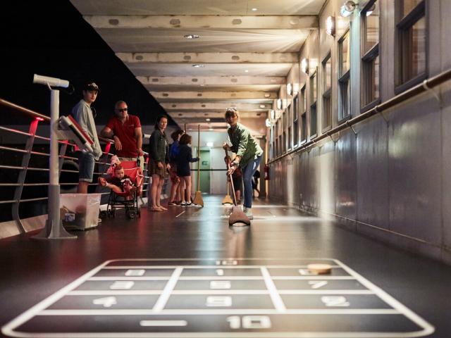 Pont promenade avec visiteurs jouant au shuffleboard jeux de pont à Escal'Atlantic.